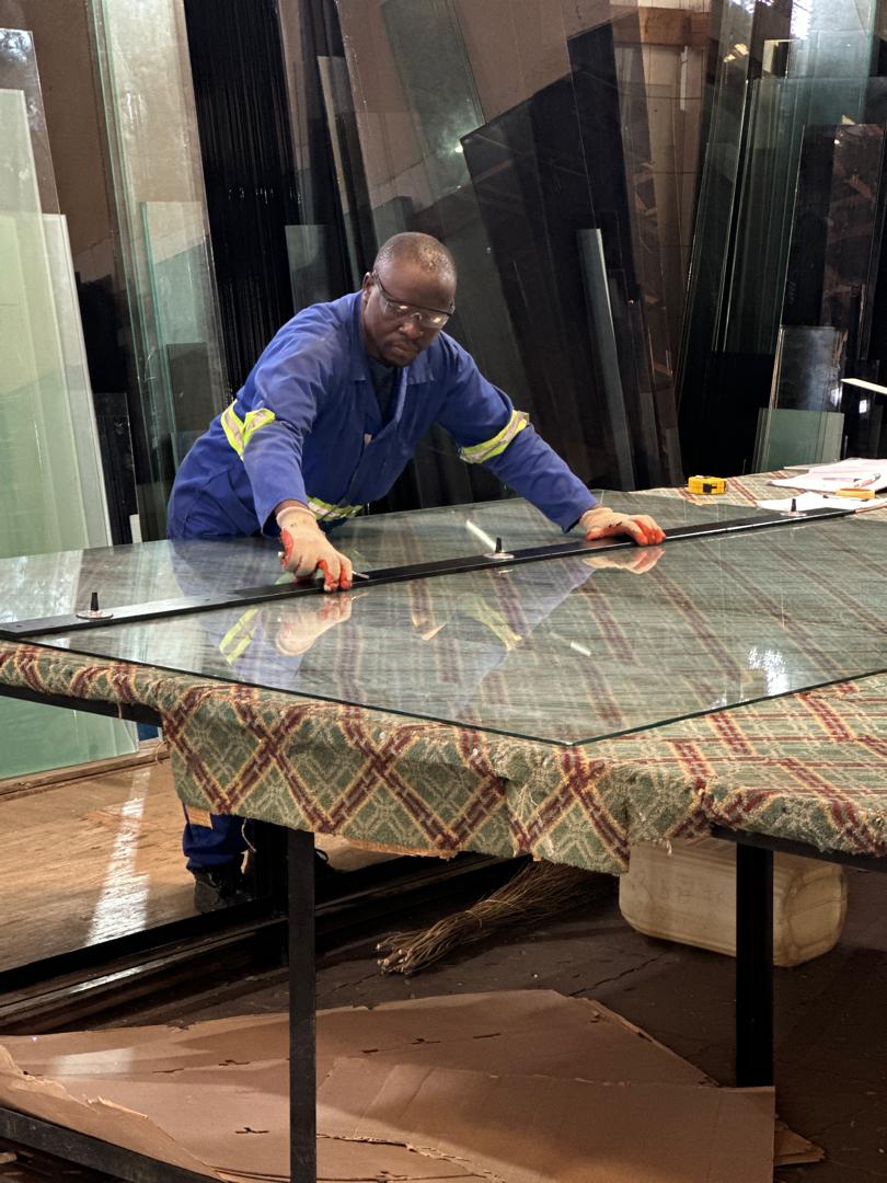 RDH Glazing technician measuring and cutting glass